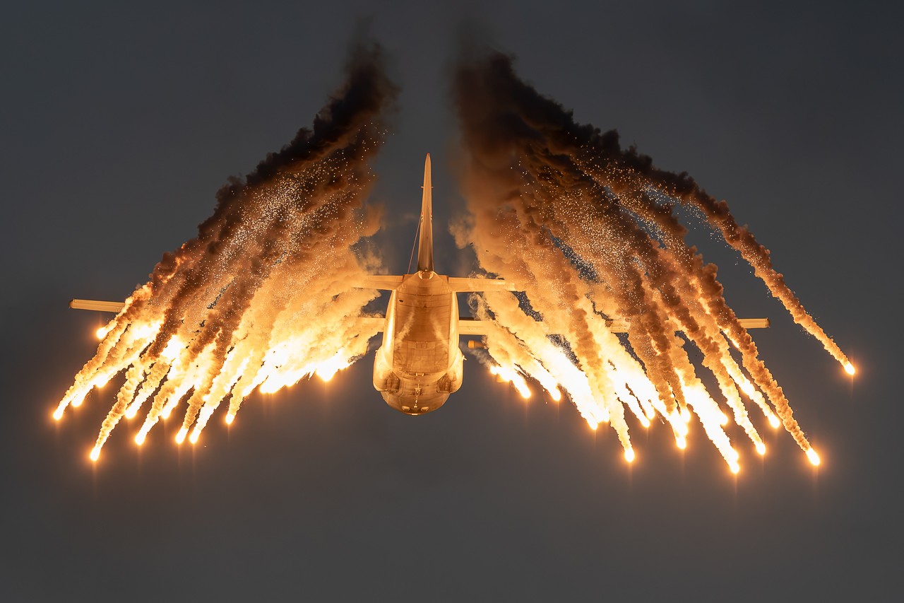 South African Air Force Lockheed C-130BZ Hercules 401 releasing flares over Waterkloof Air Base, photographed from below by Mason Stretch